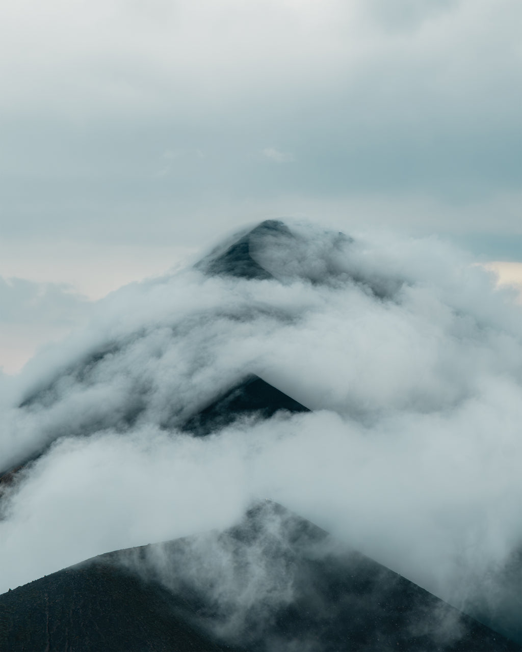 Mountain peak partially covered by clouds in Mount Fuego, Guatemala.