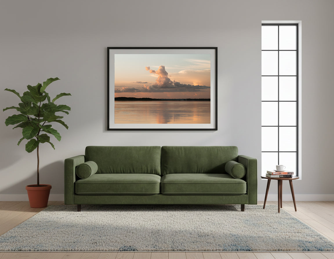 Framed beautiful, orange and peach sunset over a calm body of water with large clouds in the sky in the Amazon in Peru.