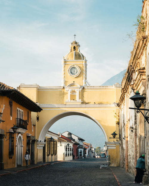 Architectural landmark with clock tower in a city street at dawn, in Antigua, Guatemala.
