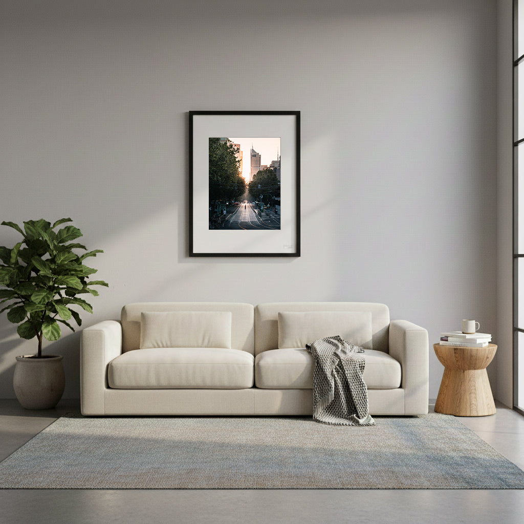 Framed city street with tall buildings and trees lining the road during sunset in Melbourne, Australia.