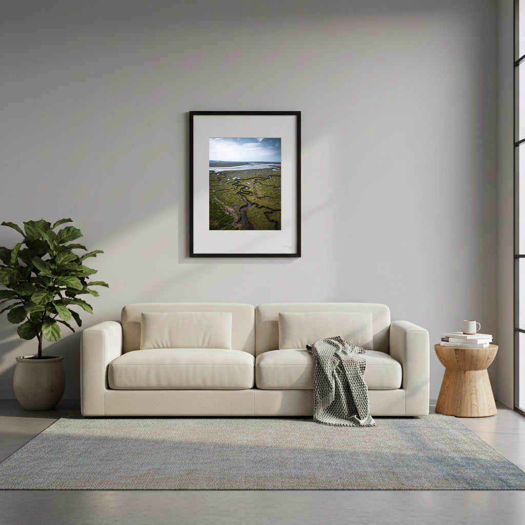 Framed wetland landscape with winding rivers and marshes under a blue sky in Norfolk, UK.