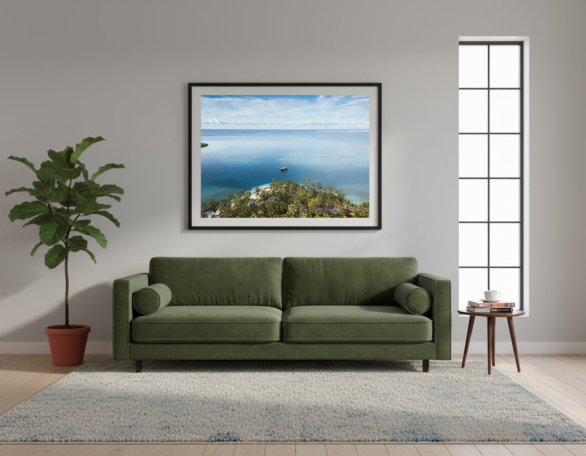 Framed island with palm trees and a boat in the middle of clear blue water in San Blas, Panama.