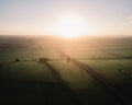 Dramatic sunrise over a rural landscape with fields and a road in England, United Kingdom.