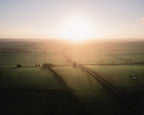 Dramatic sunrise over a rural landscape with fields and a road in England, United Kingdom.