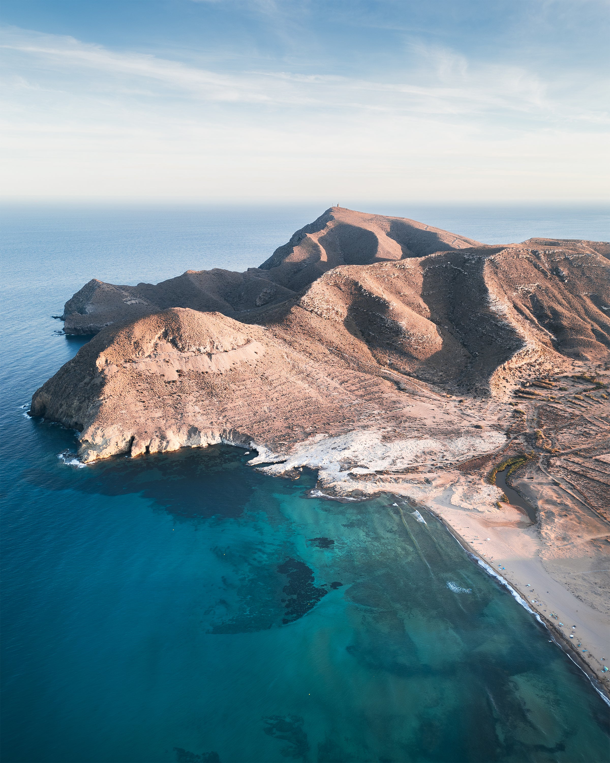 Mountains with rugged coastline and clear blue water, in Cabo de Gata, Spain.