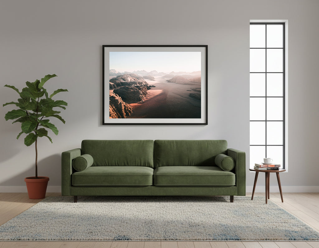 Framed desert aerial landscape with rocky formations and a vast expanse of sand at dawn, in Wadi Rum, Jordan.